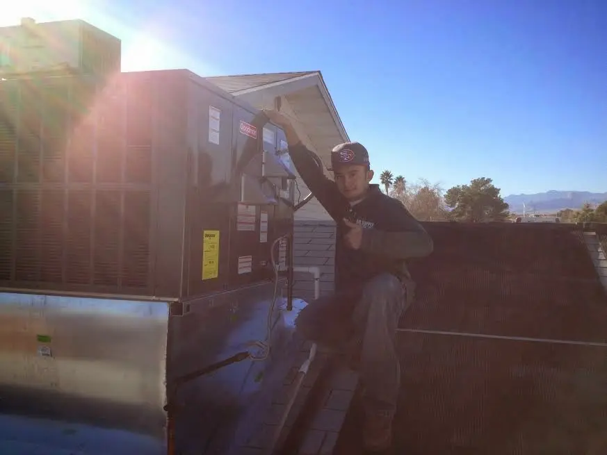 HVAC technician performing Boiler Repair on a rooftop unit in North Highlands
